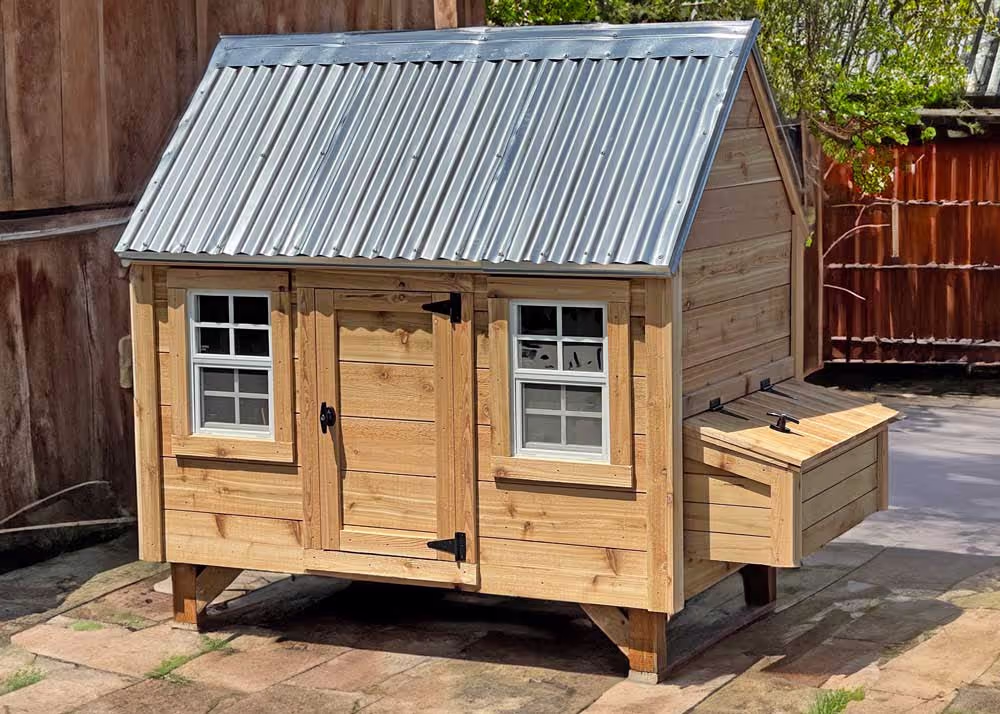 A large hen hut chicken coop with custom tongue and groove cedar siding and metal roof