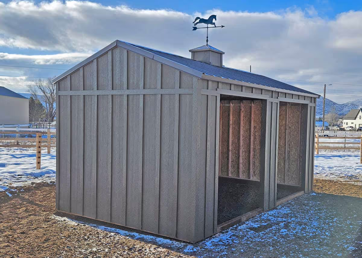 A horse loafing shed or animal shelter with a weathervane on the roof