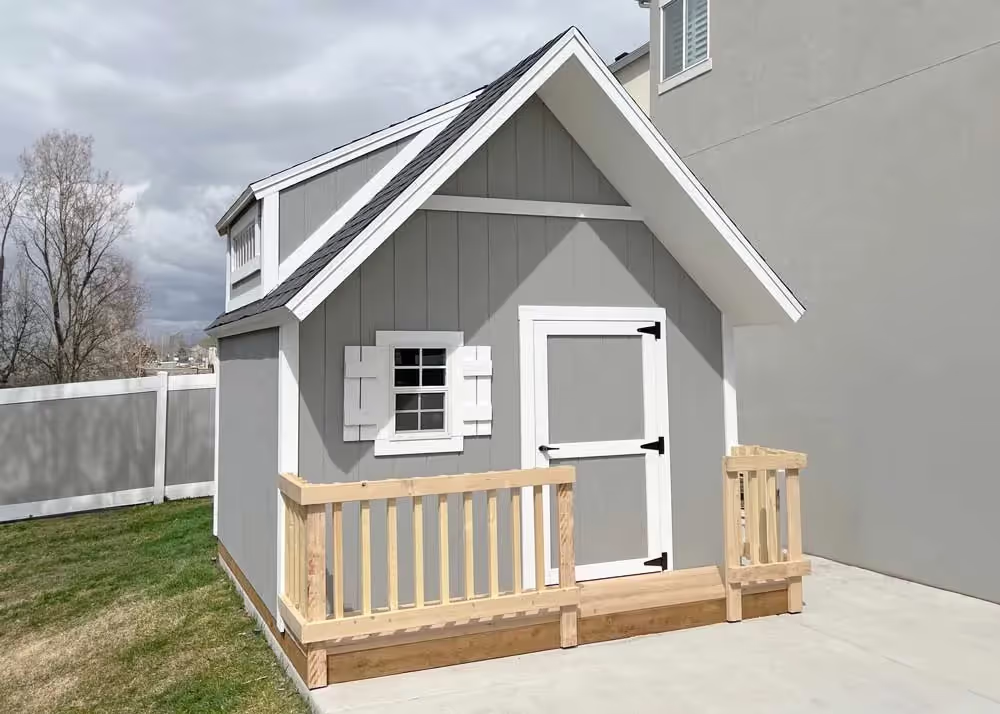 A 10 foot by 12 foot clubhouse playhouse with porch railing and double dormers