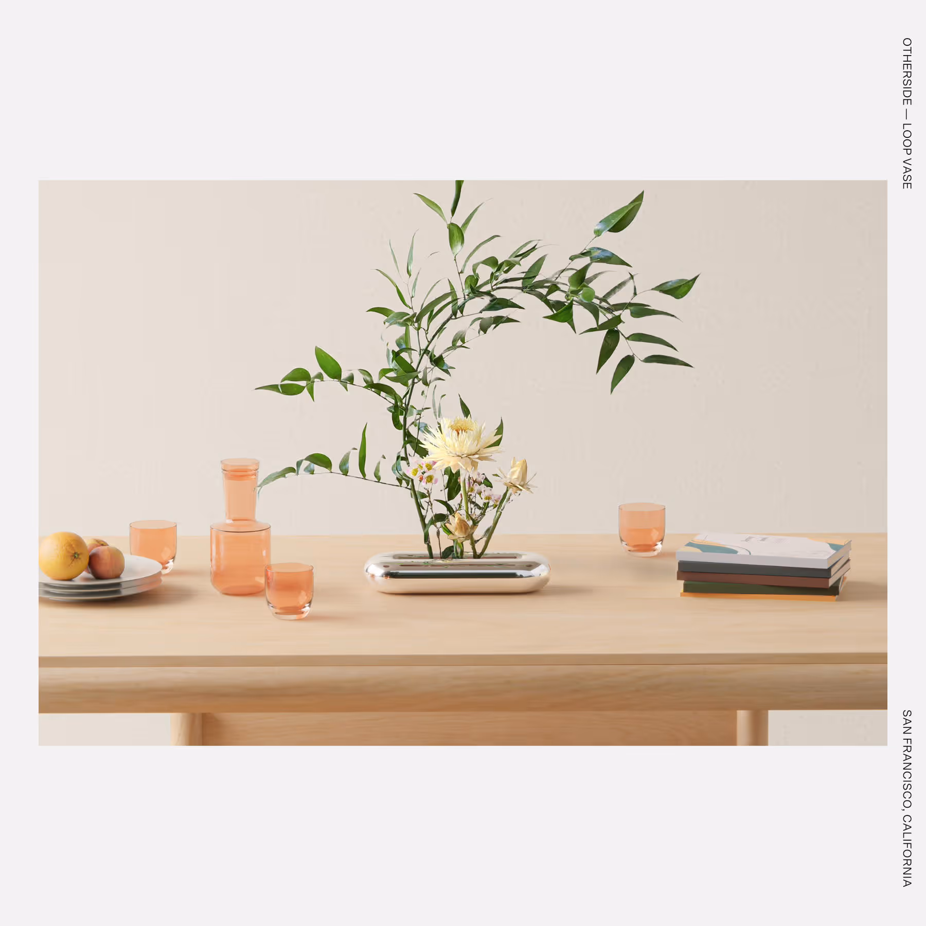 The Loop Vase displayed with flowers, emphasizing its sculptural, ribbon-like curves.