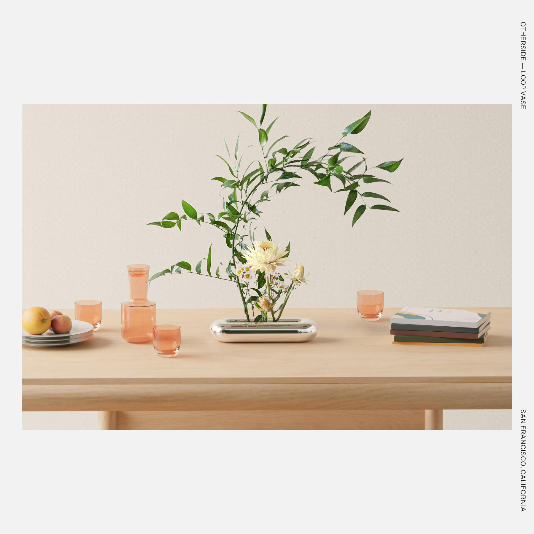 The Loop Vase displayed with flowers, emphasizing its sculptural, ribbon-like curves.