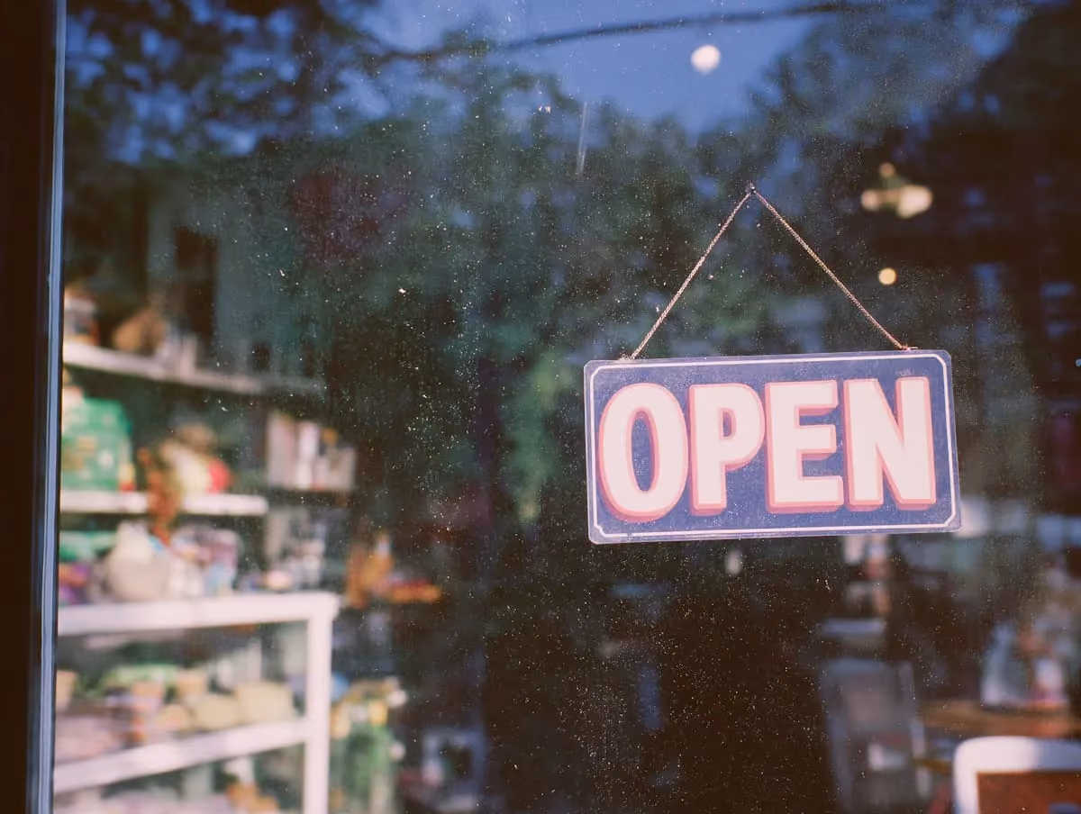 Open sign hanging in a small business storefront window