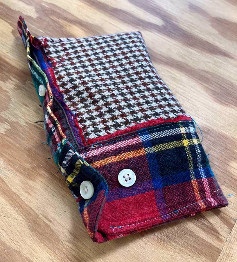 A pencil case made from an upcycled plaid shirt sleeve and scrap fabric.