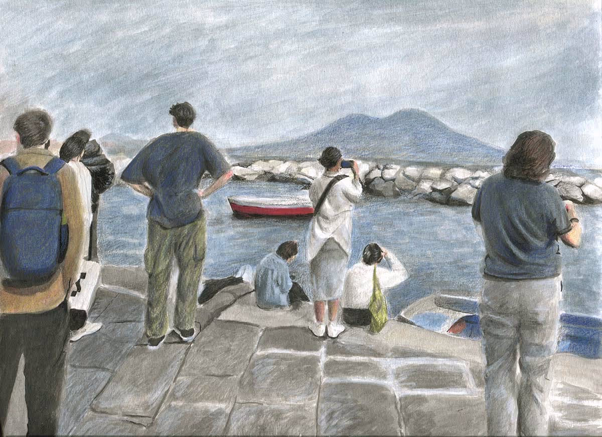 A group of students standing around or sitting by the water in Naples with Mt. Vesuvius in the background.