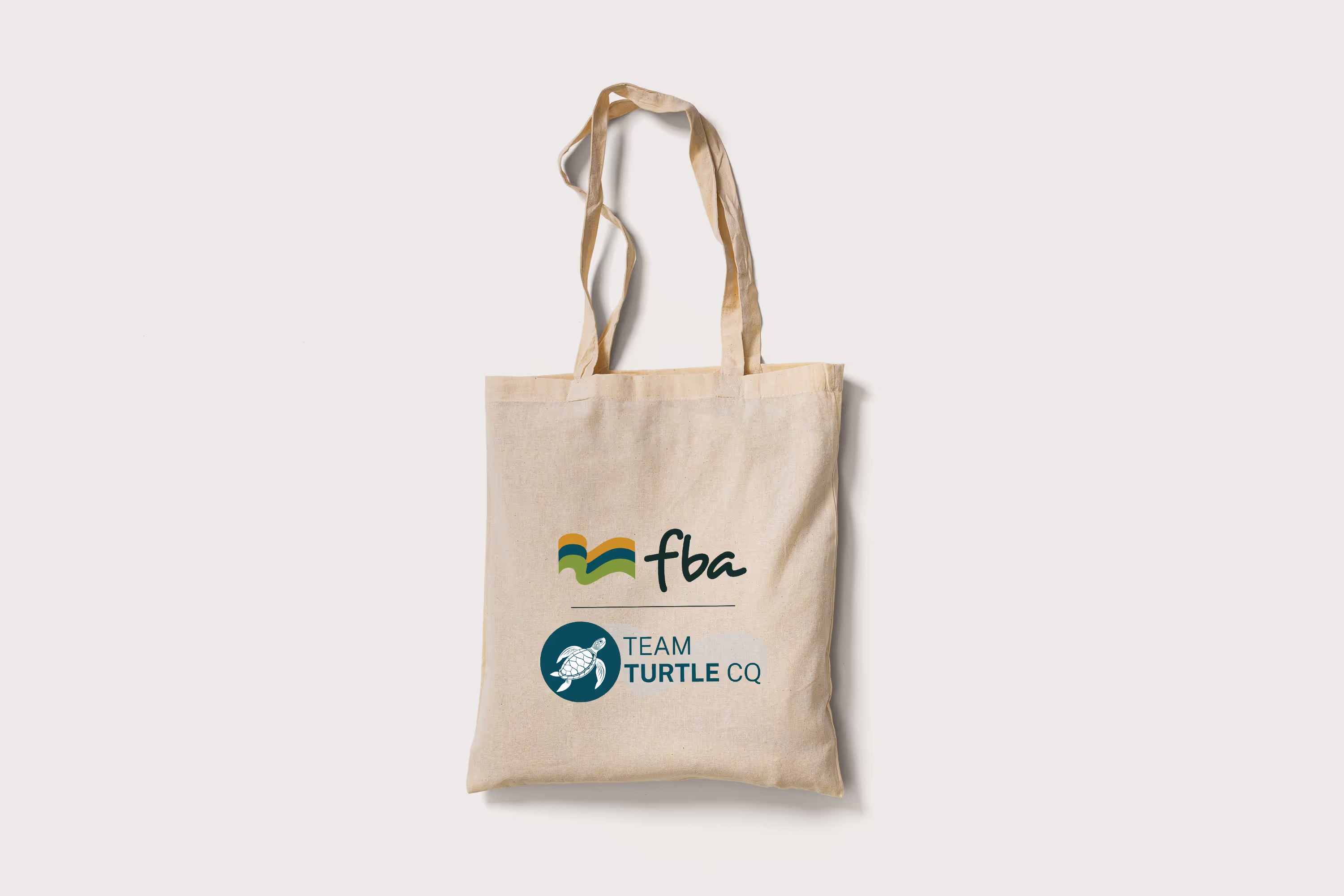 A calico tote bag with the FBA and Team Turtle CQ logos.