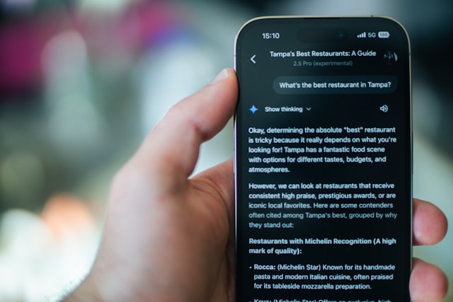 A close-up shot of a person using a smartphone to search for a restaurant on a map application, showing navigation and location services.
