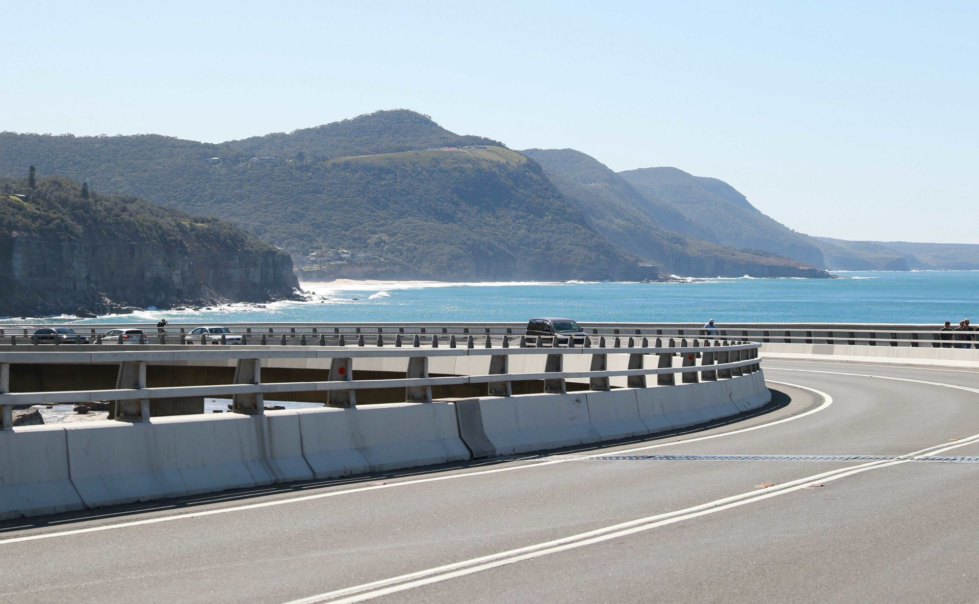 Scenic Pacific Coast Highway curves with ocean views mountains and guardrails