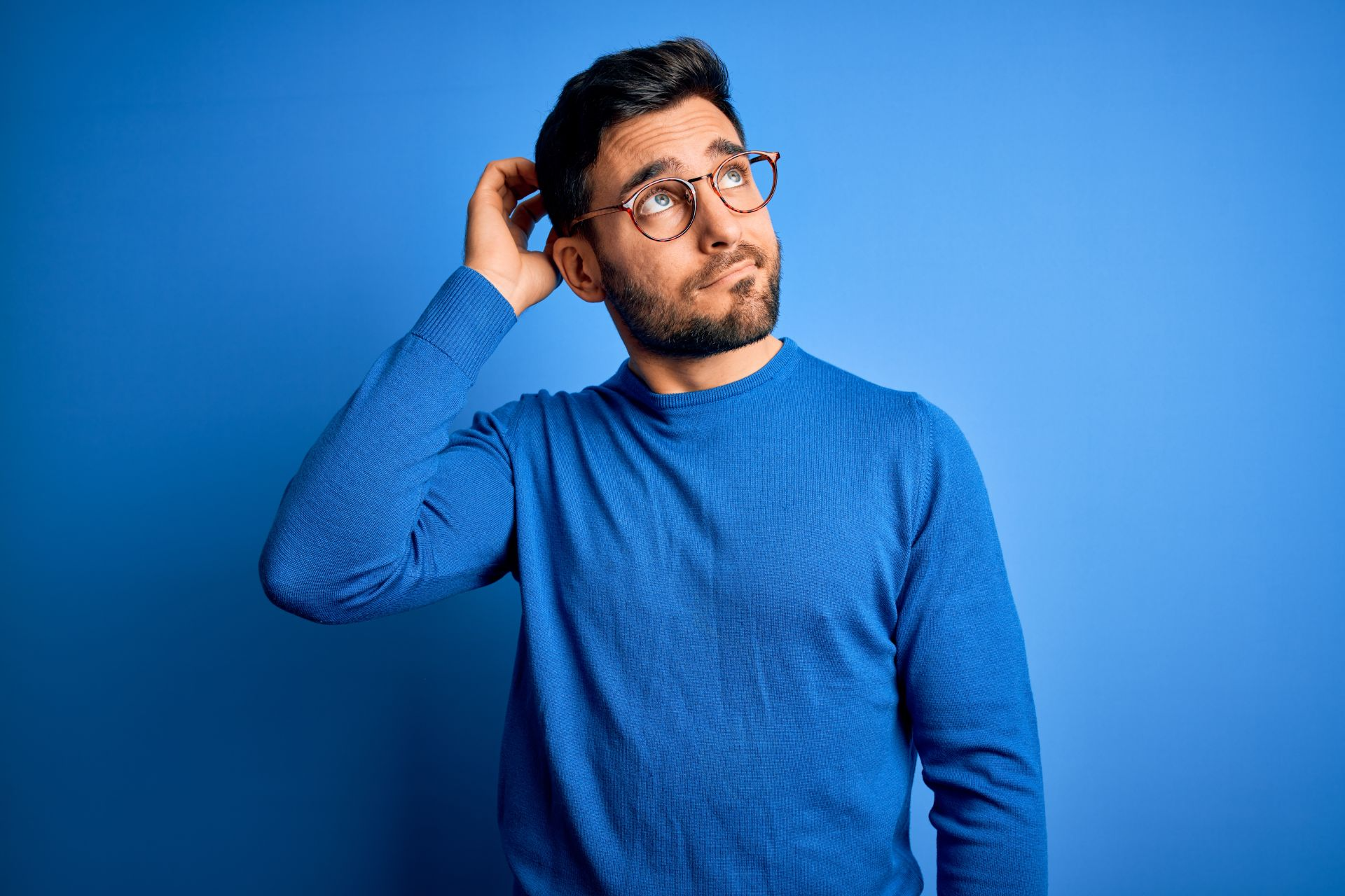 Hombre pensativo considerando opciones para comprar carros baratos en Los Angeles California