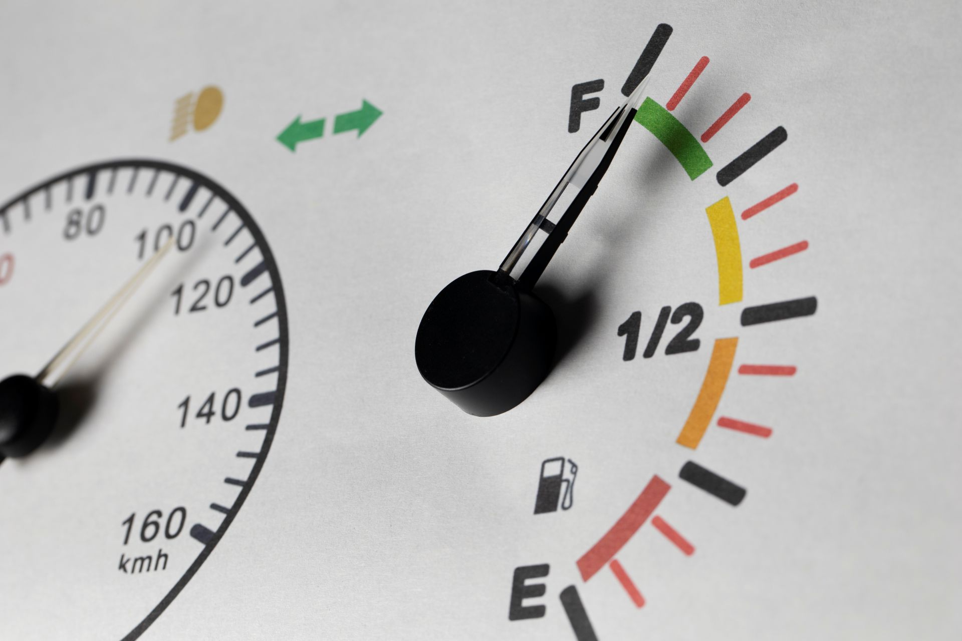 Car fuel gauge showing half tank with speedometer indicating fuel economy monitoring for better gas mileage