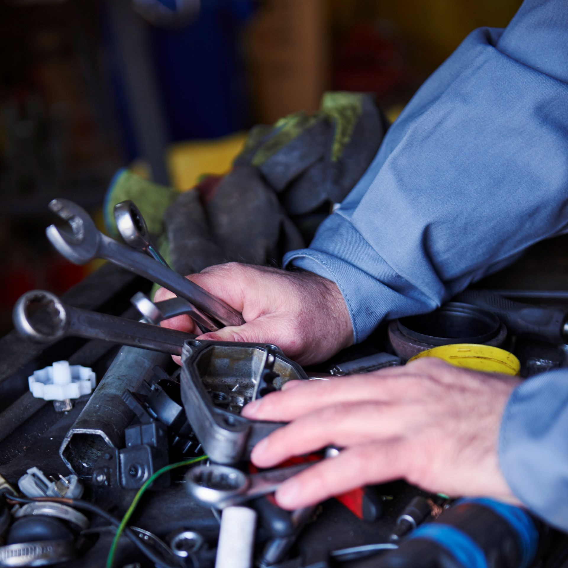 Mechanic hands working on truck engine with tools showing maintenance to improve gas mileage and fuel efficiency