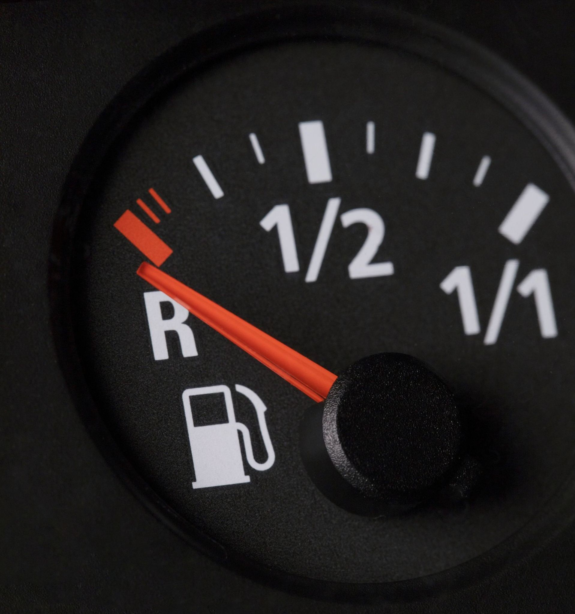 Vehicle fuel gauge on empty with red warning indicator showing low gas mileage and need for fuel efficiency improvements
