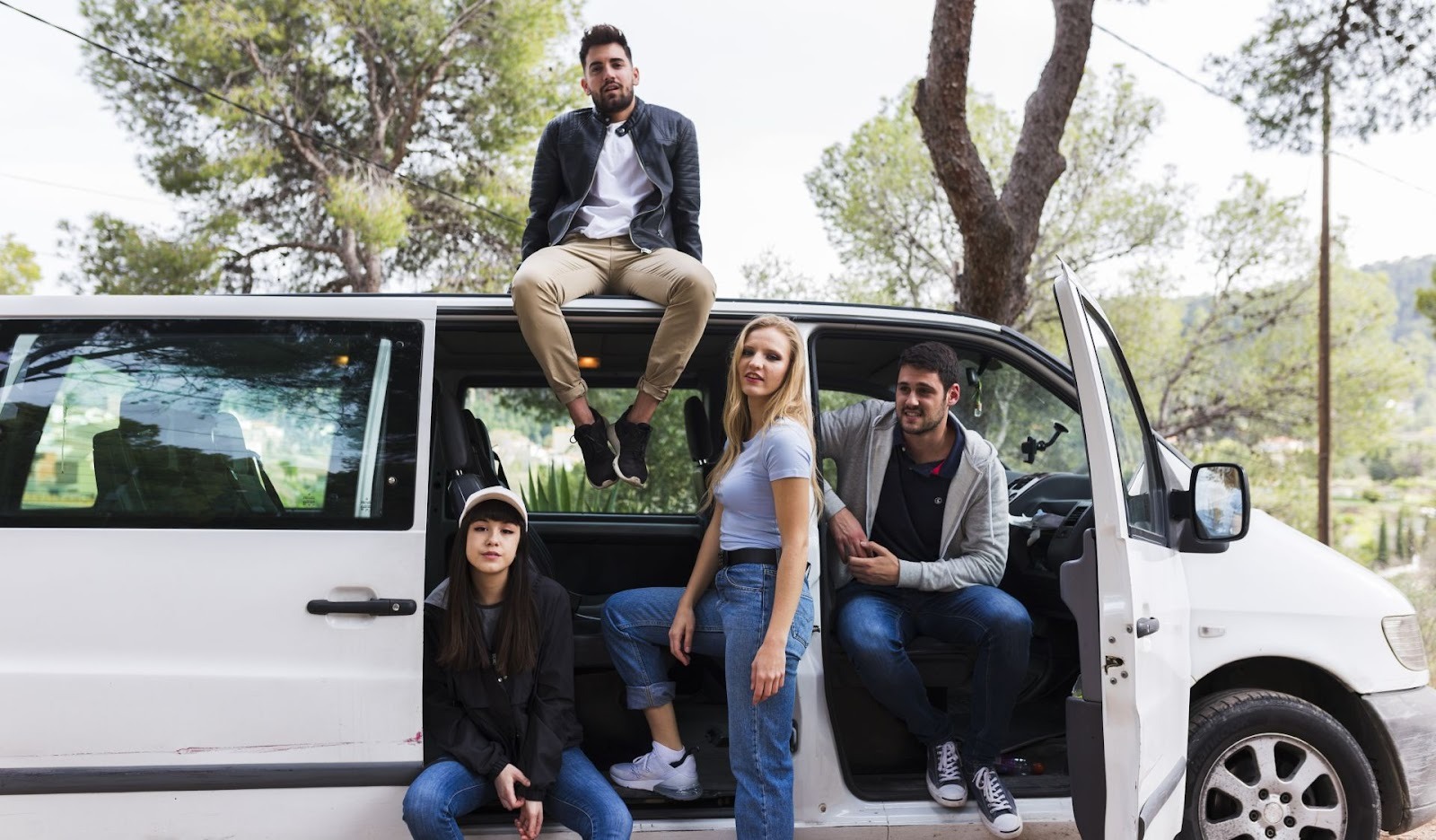 Minivan vs wagon comparison featuring white family van with passengers in outdoor setting