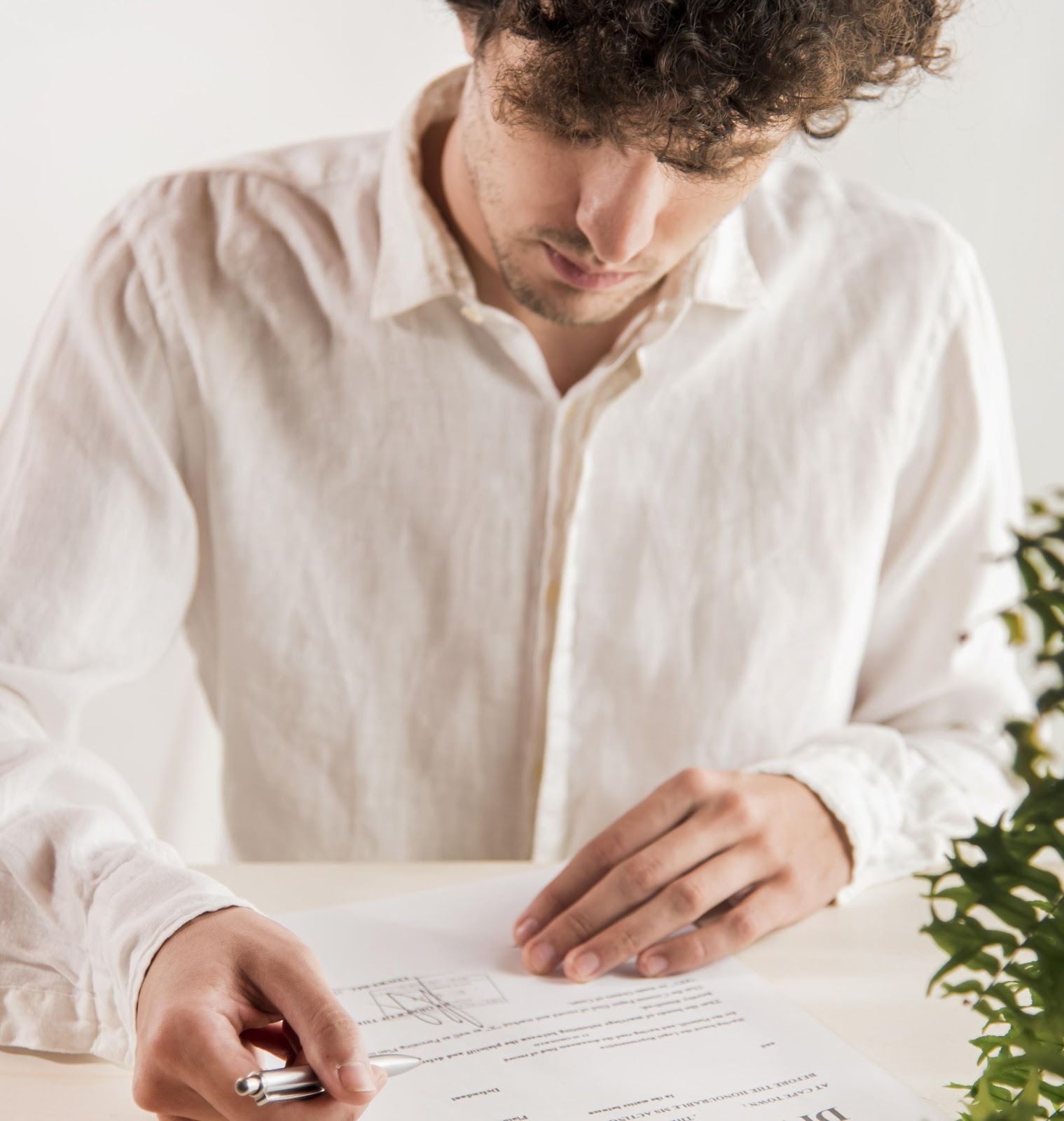 Man carefully reviewing new car contract documents before signing purchase agreement