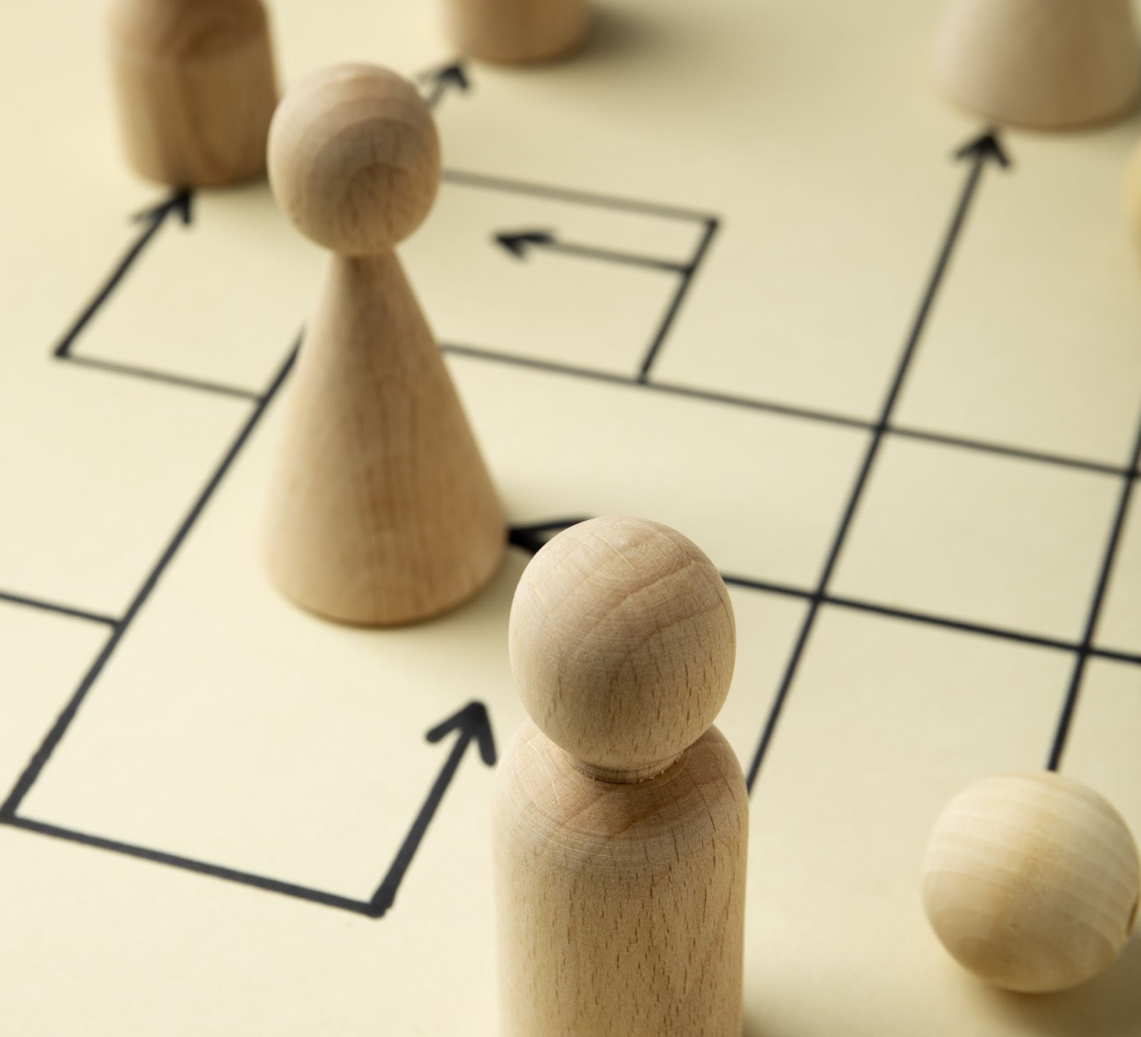 Fichas de madera sobre tablero estratégico representando tácticas de venta de concesionarios