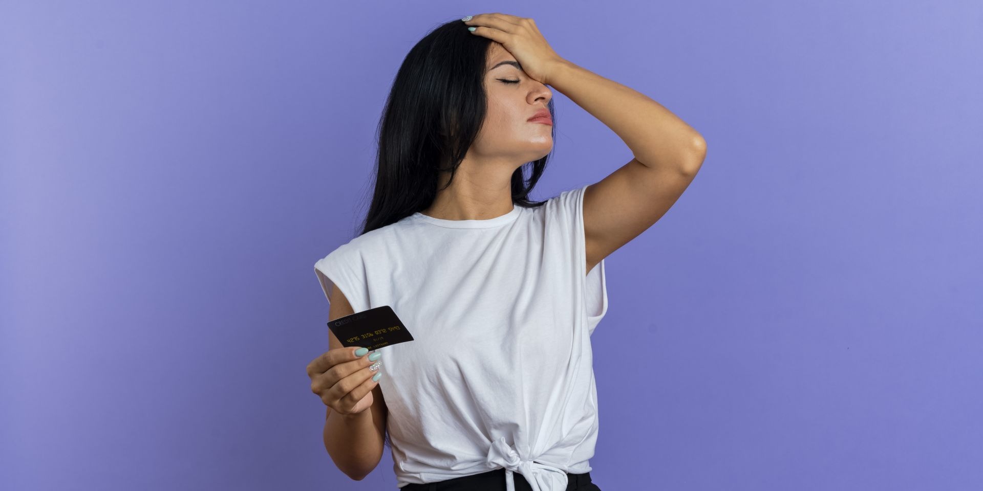 Mujer estresada sosteniendo tarjeta de crédito con expresión de preocupación por olvidar su pago