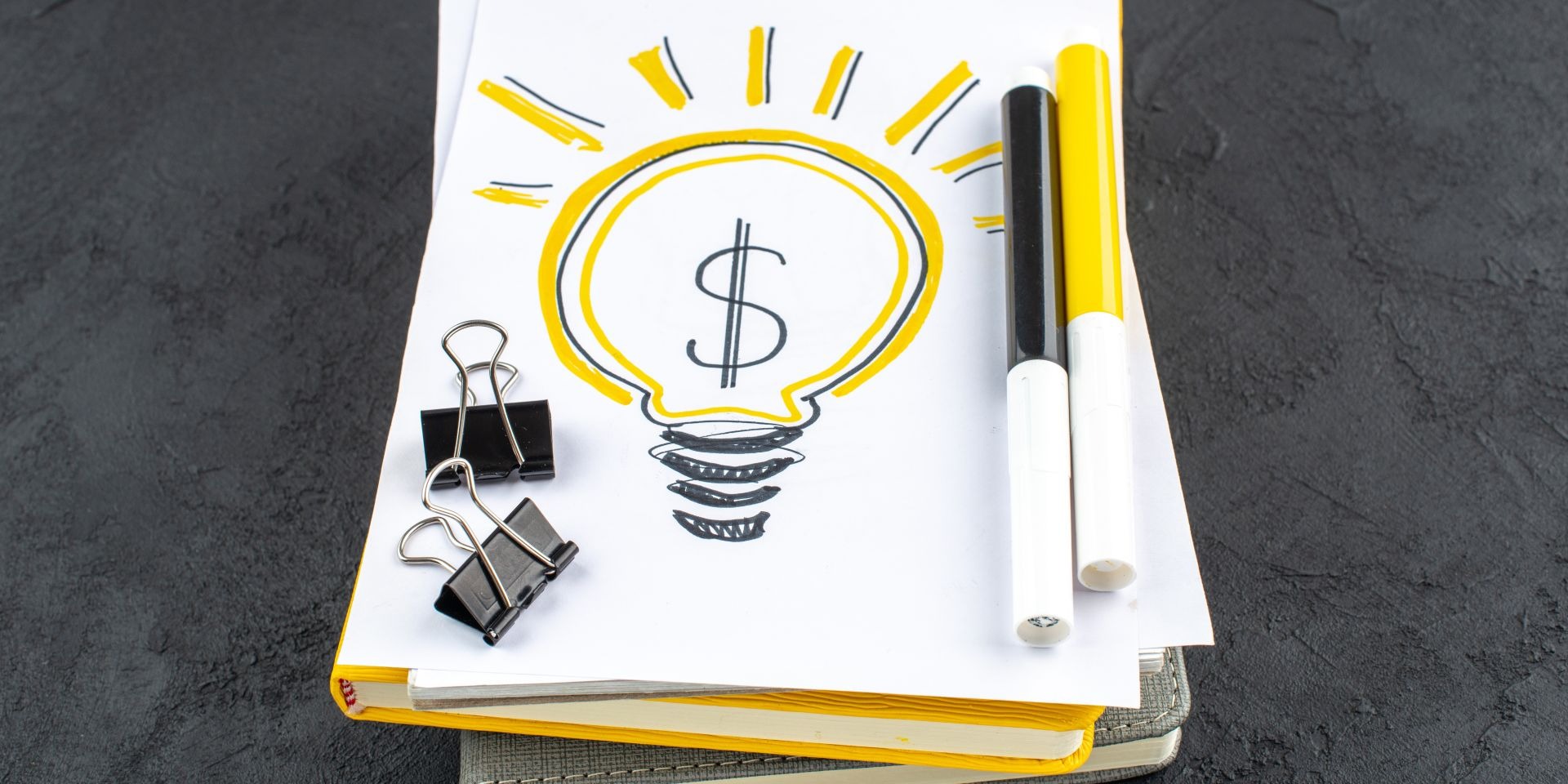 Dibujo de foco con símbolo de dólar en libreta representando ideas de ahorro e inversión inteligente