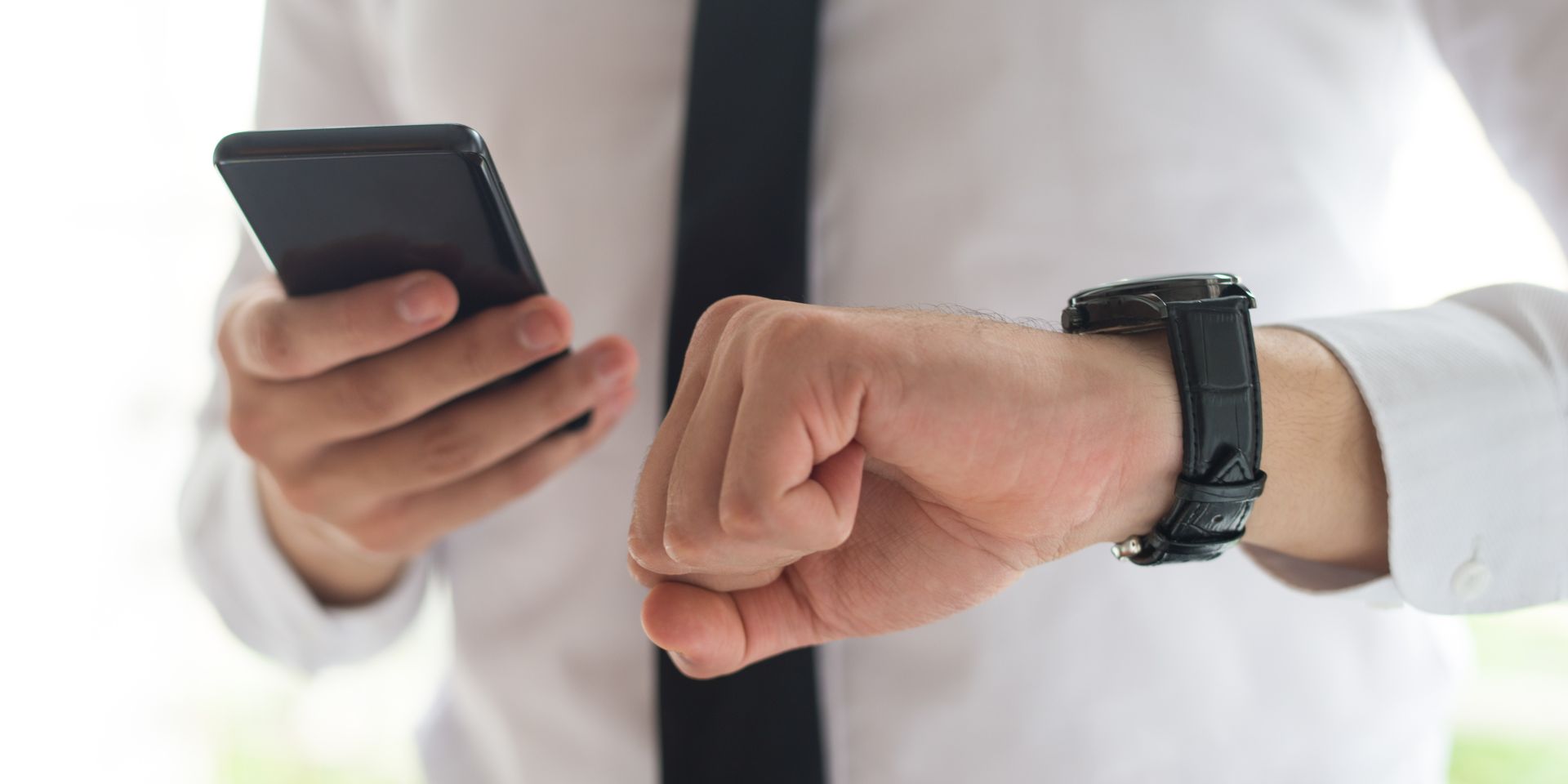 Car buying consultant checking his watch representing dealership tactics that waste your time