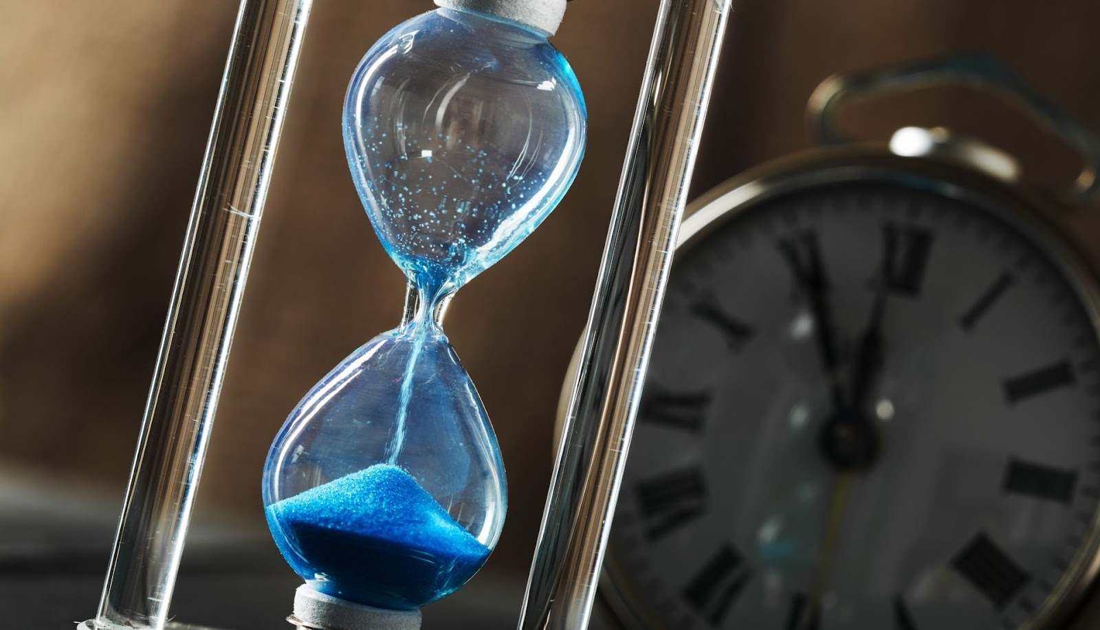 Blue hourglass with clock shows time saved using professional car buying consultation