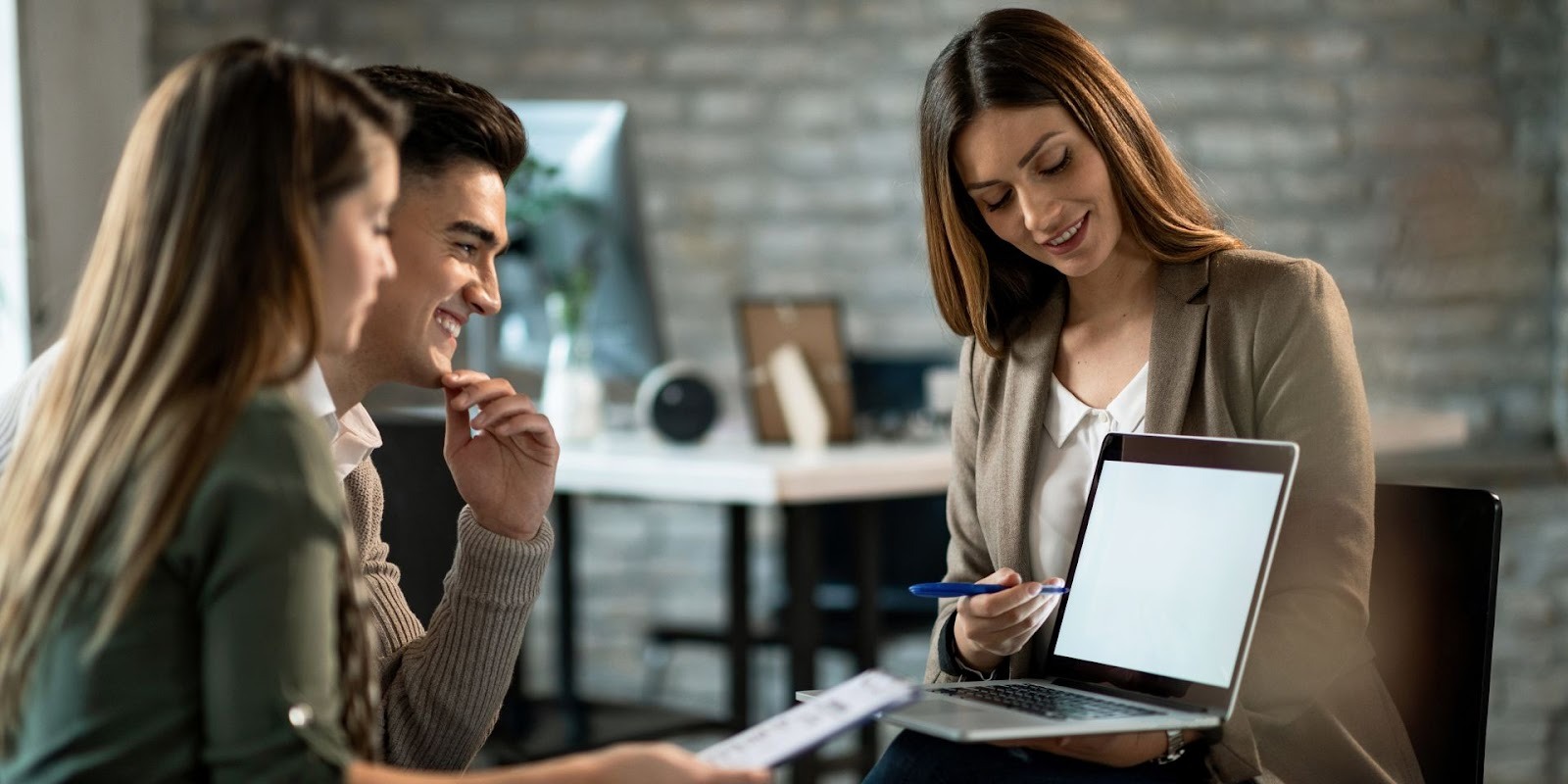 Asesora automotriz explicando regla 20 4 10 a pareja joven en oficina