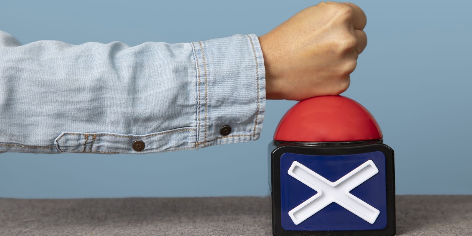 Mano presionando botón rojo de rechazo cuando no aplica regla de financiamiento automotriz 20|4|10