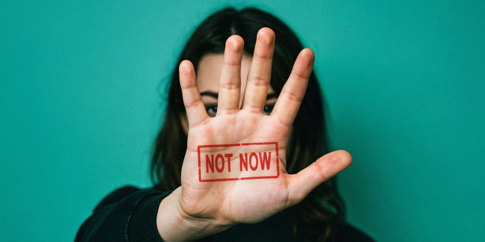 Woman showing not now hand gesture to avoid rushing into a bad car purchase decision