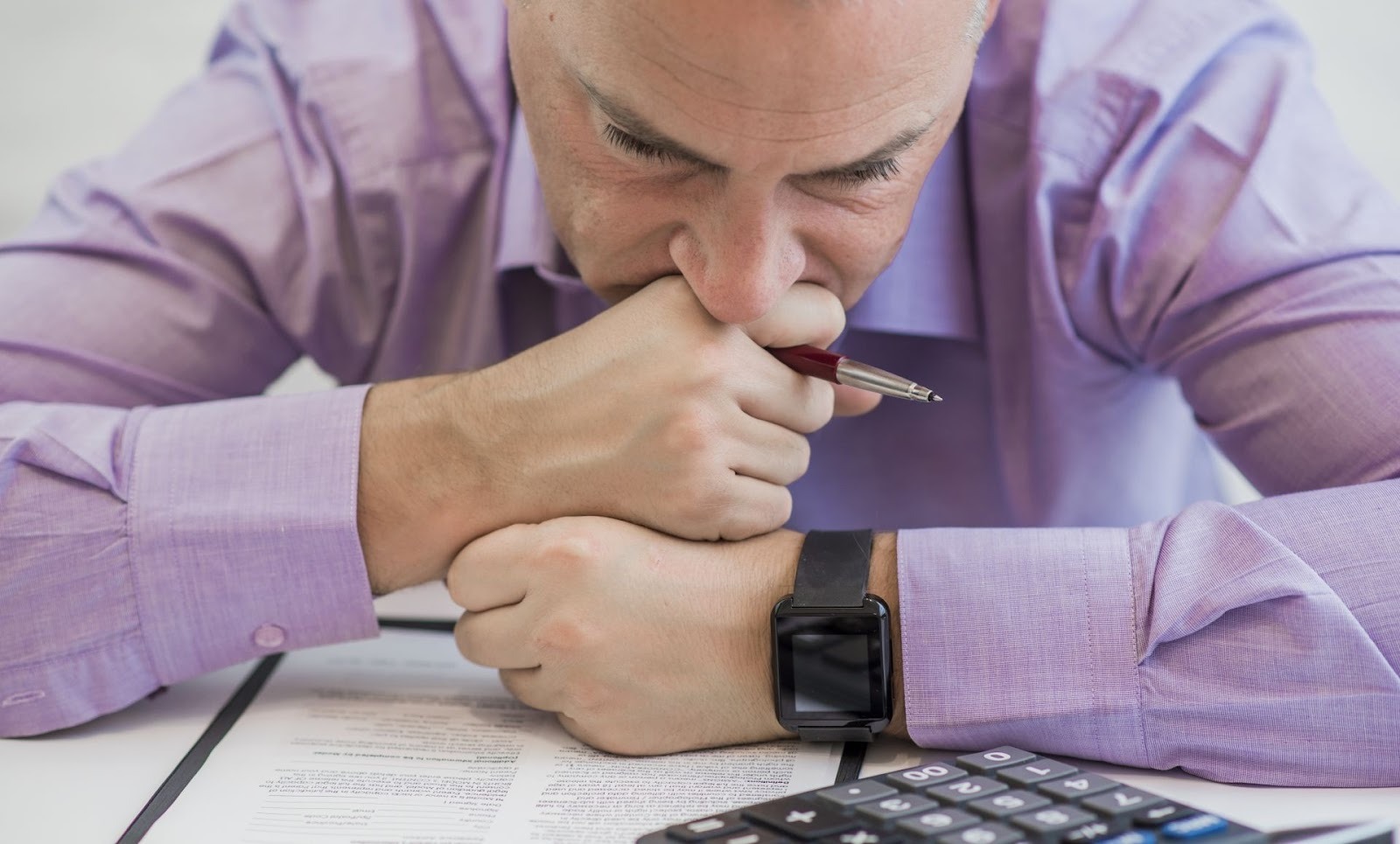 Stressed car buyer reviewing dealership contract paperwork and financing documents