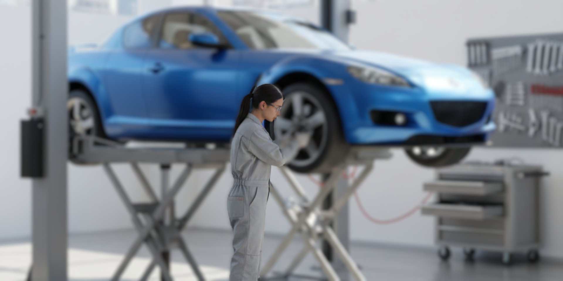 Technician inspecting a blue sport car on a hydraulic lift during scheduled service