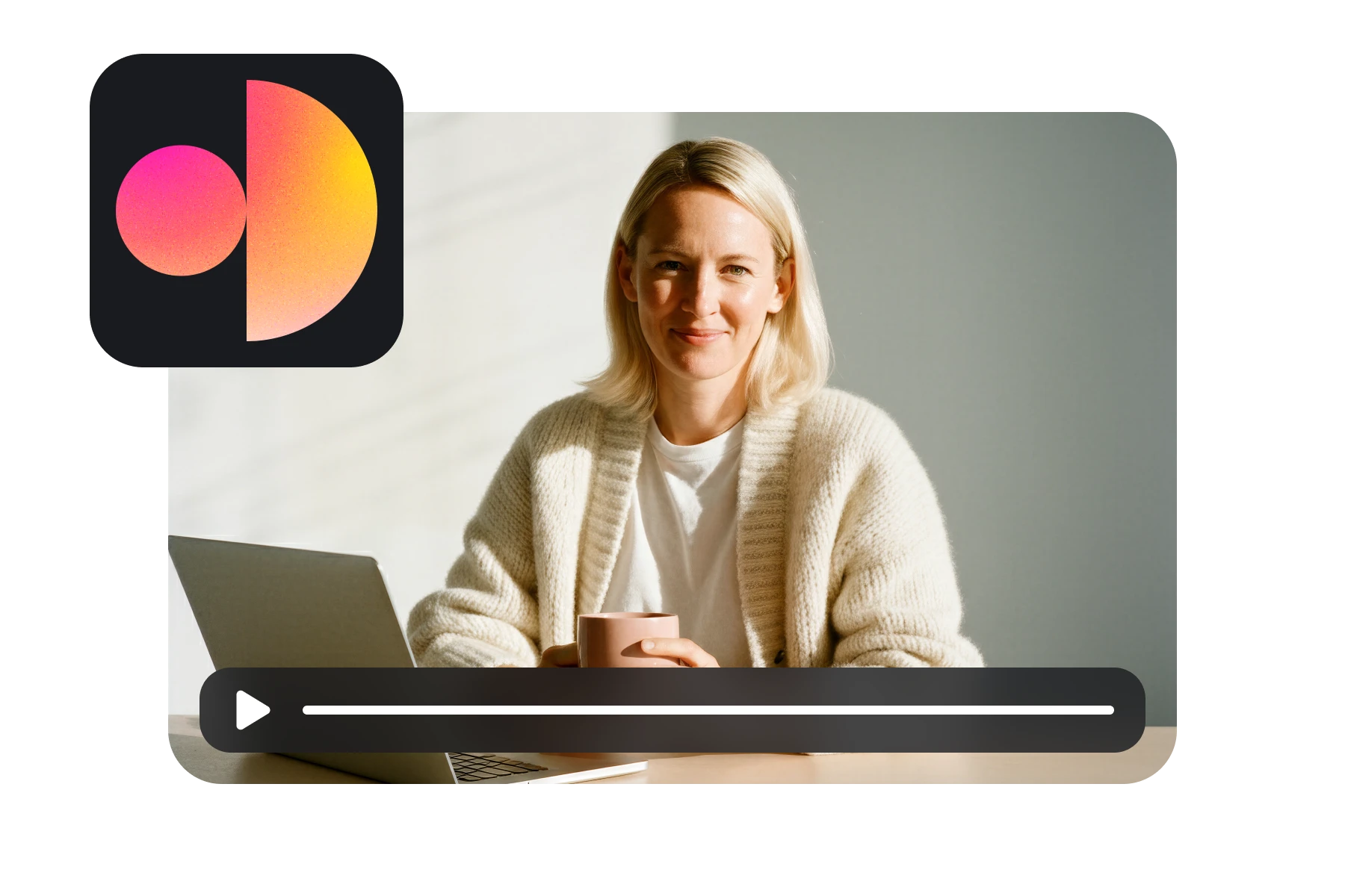 Woman with blonde hair wearing a beige cardigan, sitting at a table with a laptop and holding a pink mug, smiling at the camera.