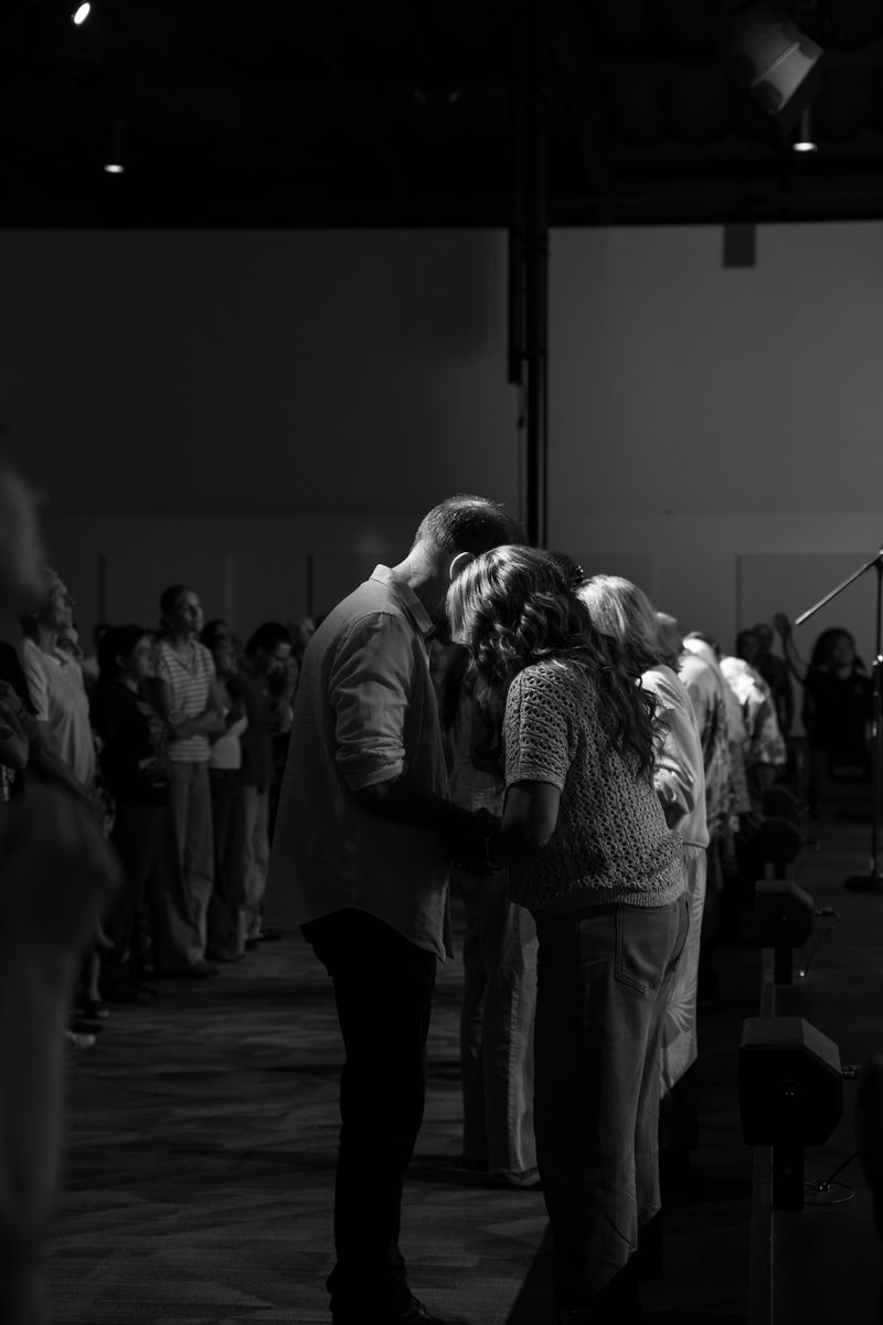 People gathered close, praying together after a service