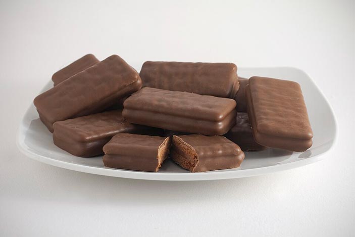 An image of a pile of chocolate Tim Tam biscuits sitting on top of a white plate.