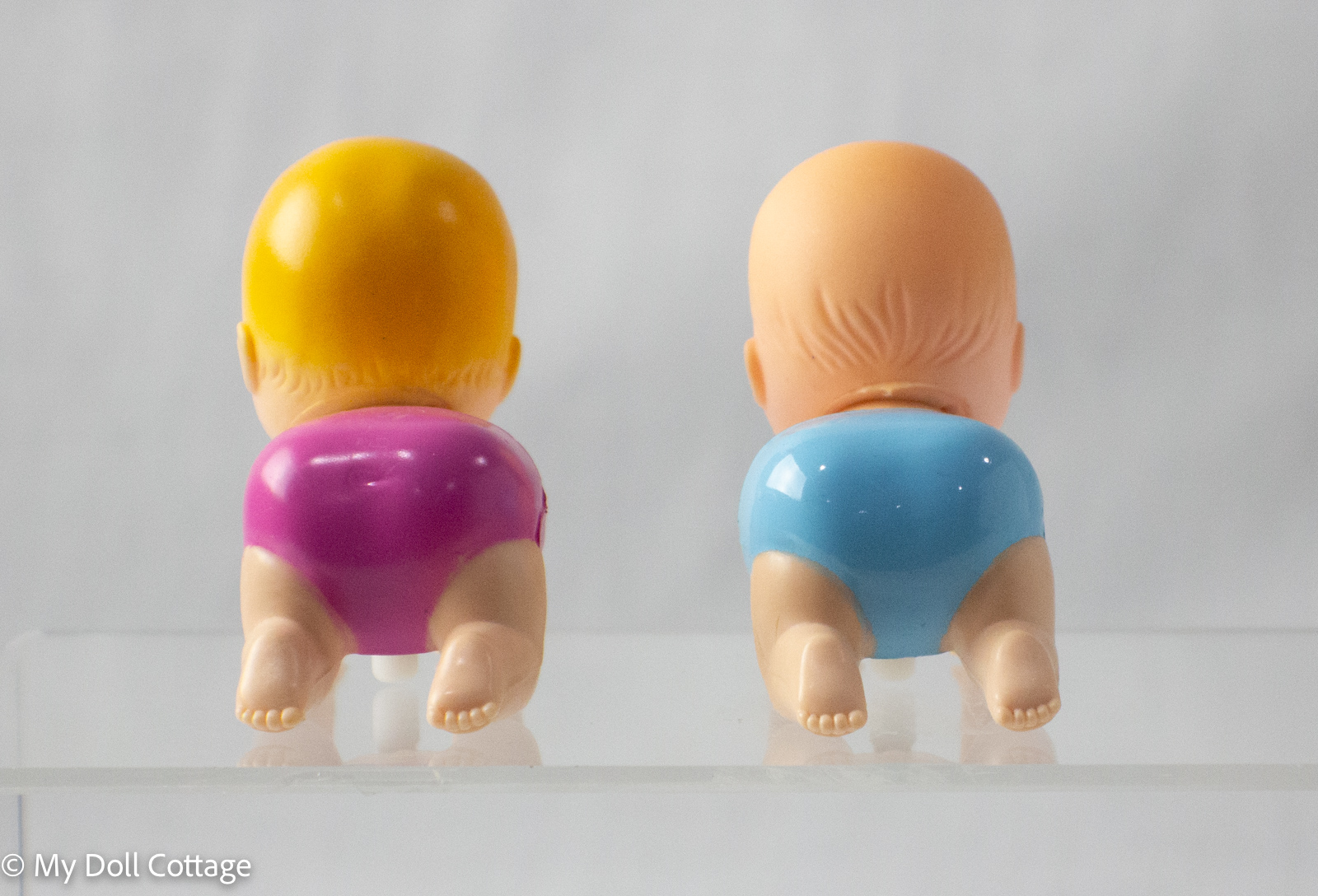 Rear view of New Ray crawling twin babies in blue and pink nappies