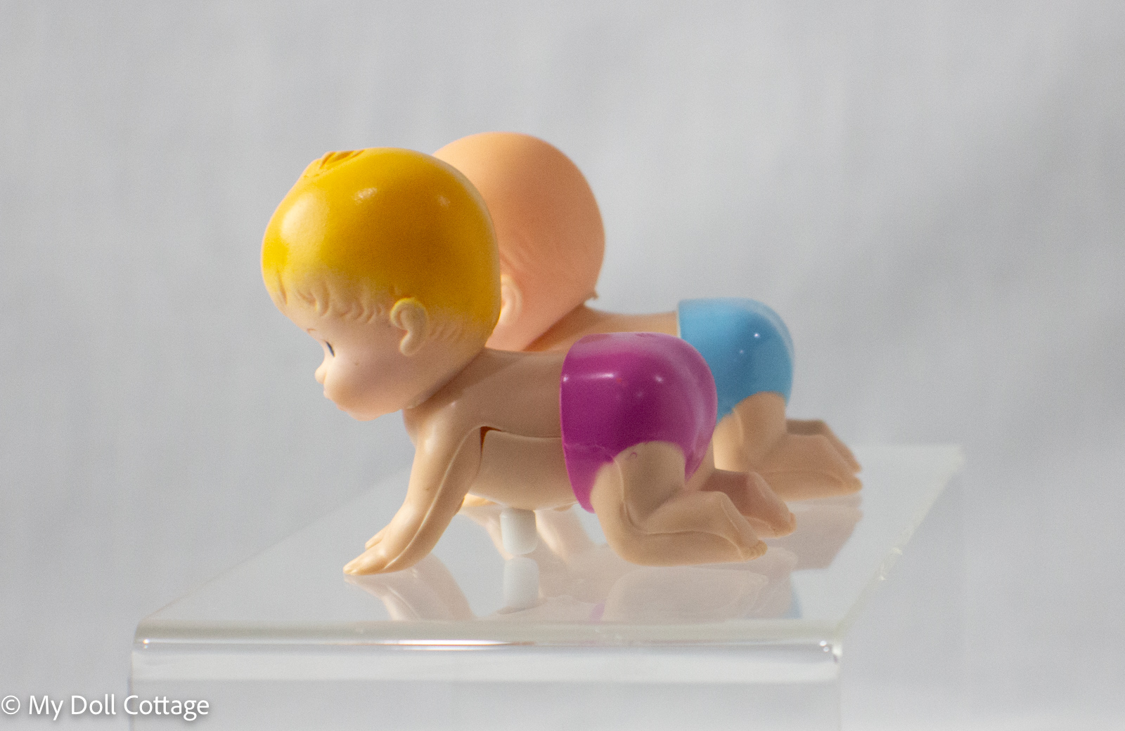 Side view of New Ray crawling baby twins showing rubber heads and plastic bodies