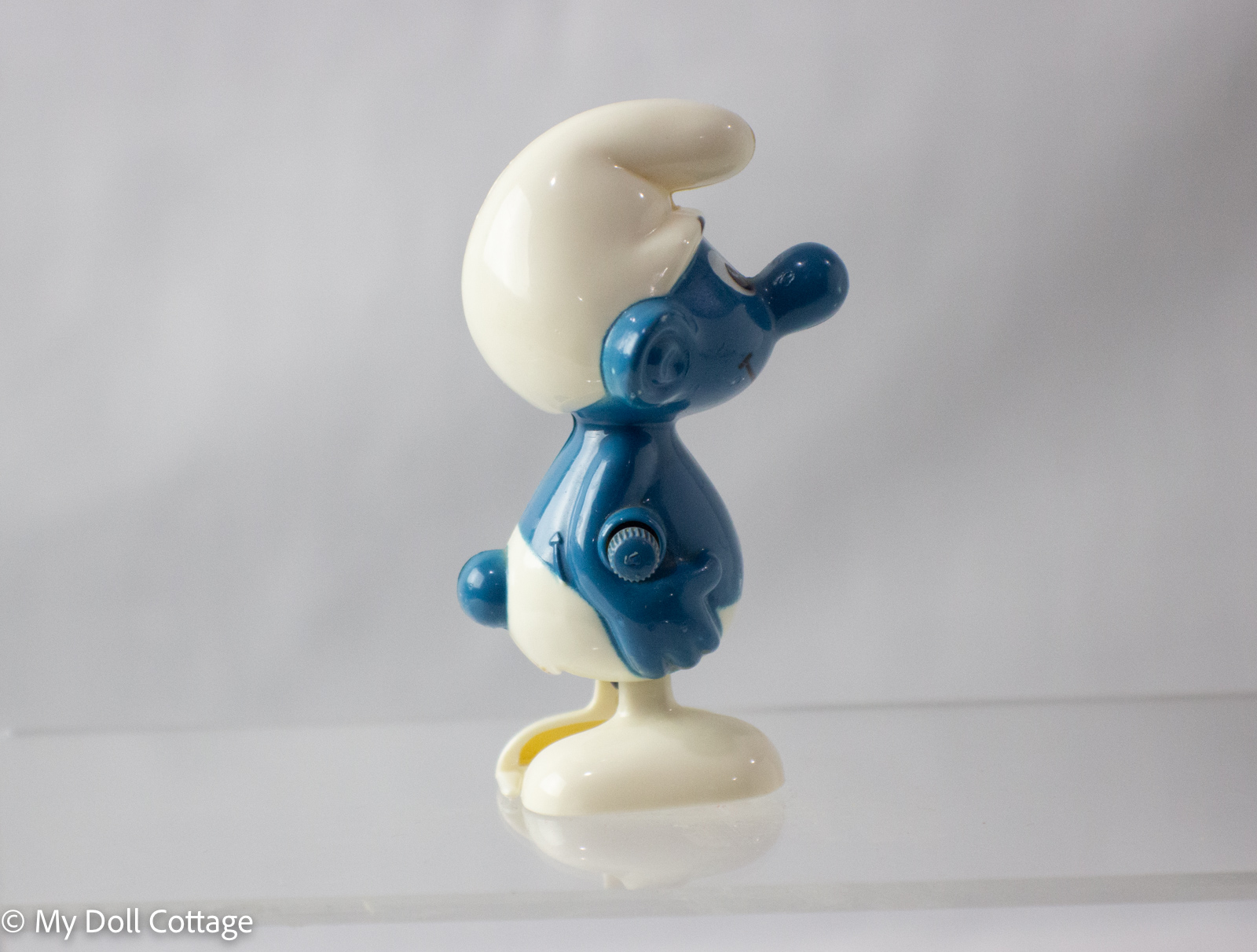 Side profile of blue Smurf toy with wind-up key visible.