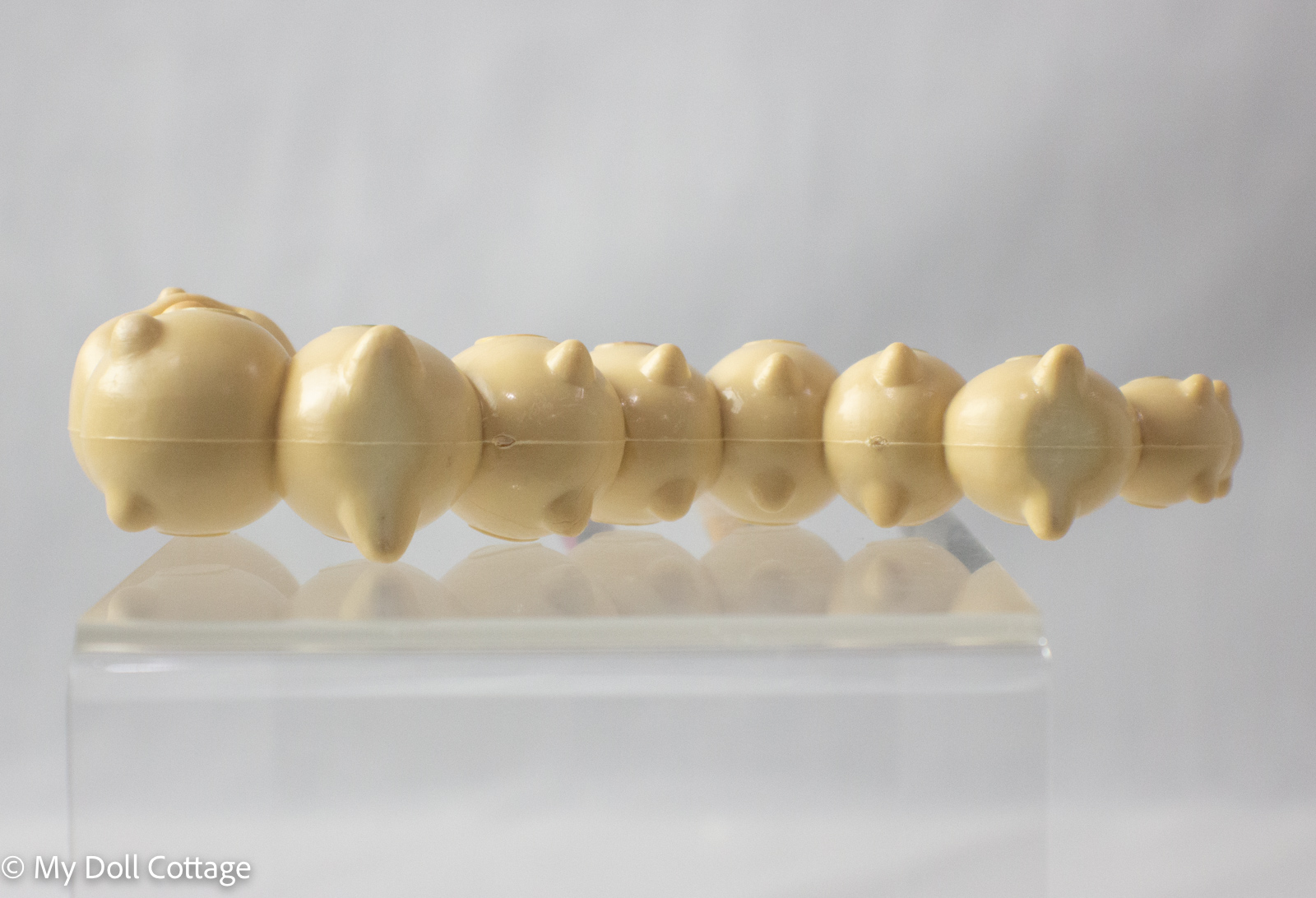 Underside view of caterpillar crayon holder showing segmented body and plain base
