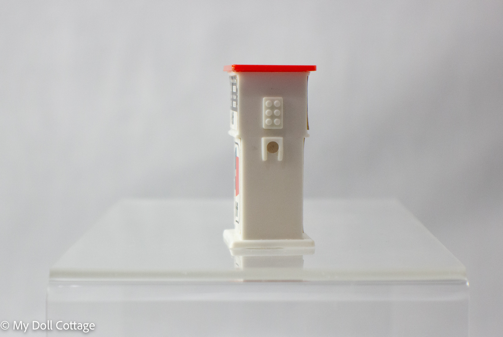 Reverse side view of white plastic petrol pump sharpener with red top.
