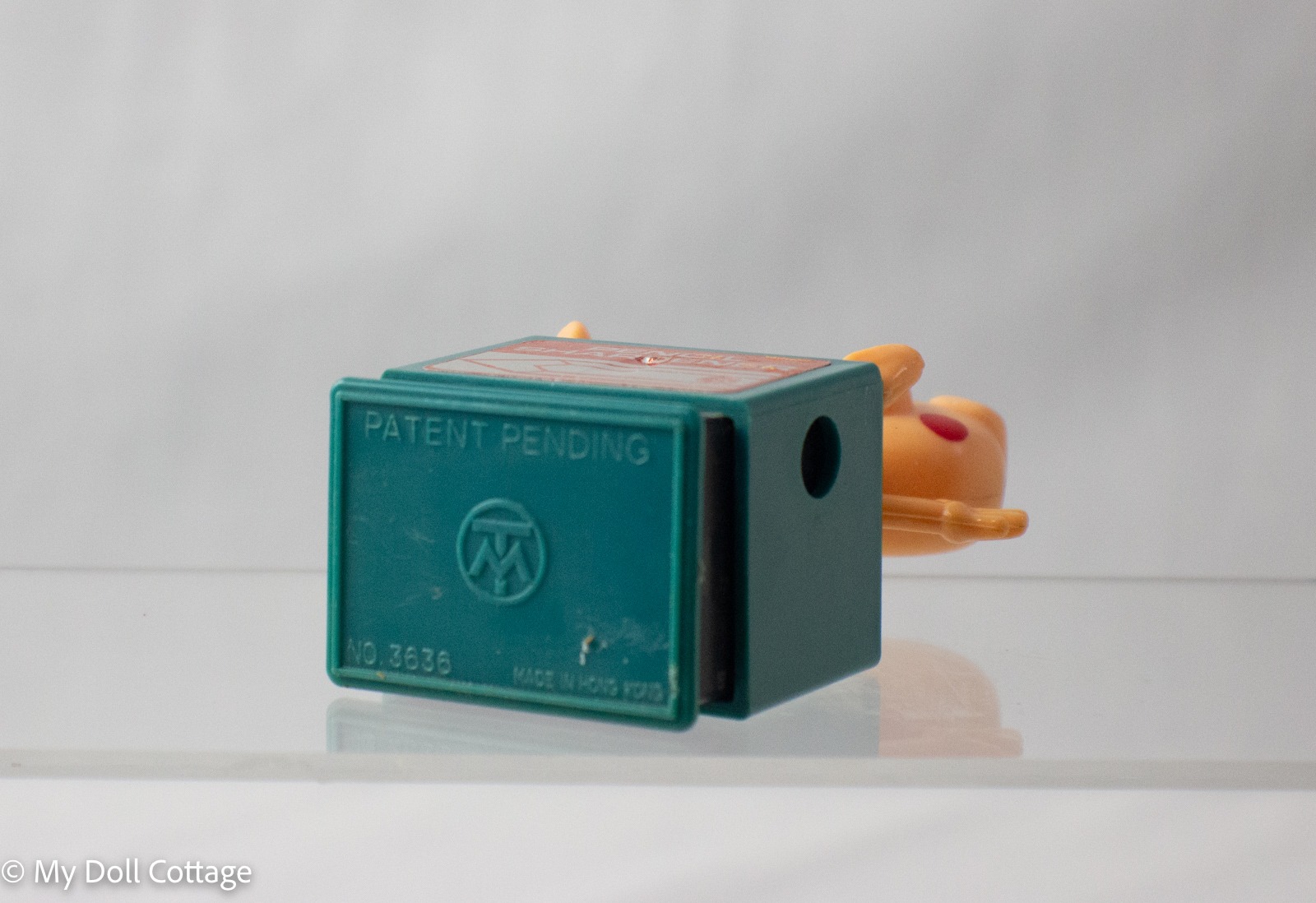 Underside of pig pencil sharpener marked Patent Pending, TM in a circle, No. 3636, Made in Hong Kong.