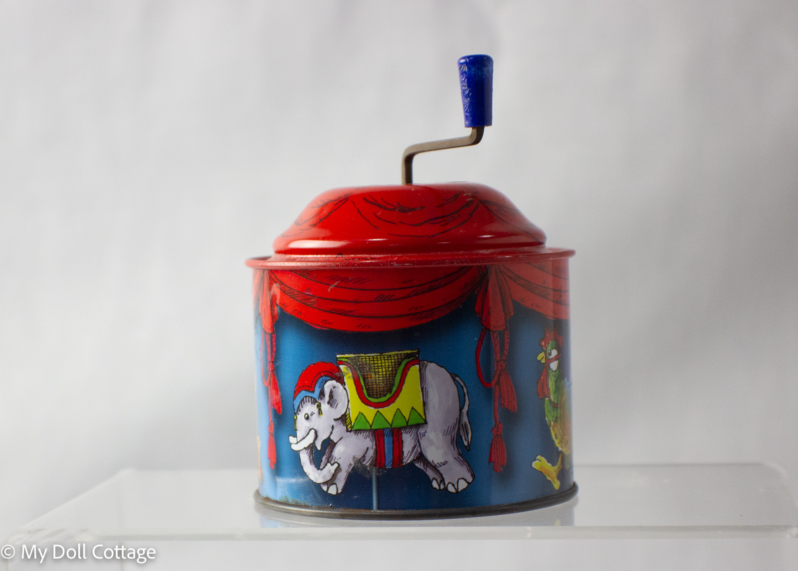 Rear view showing elephant and rooster figures with blue background and red canopy.