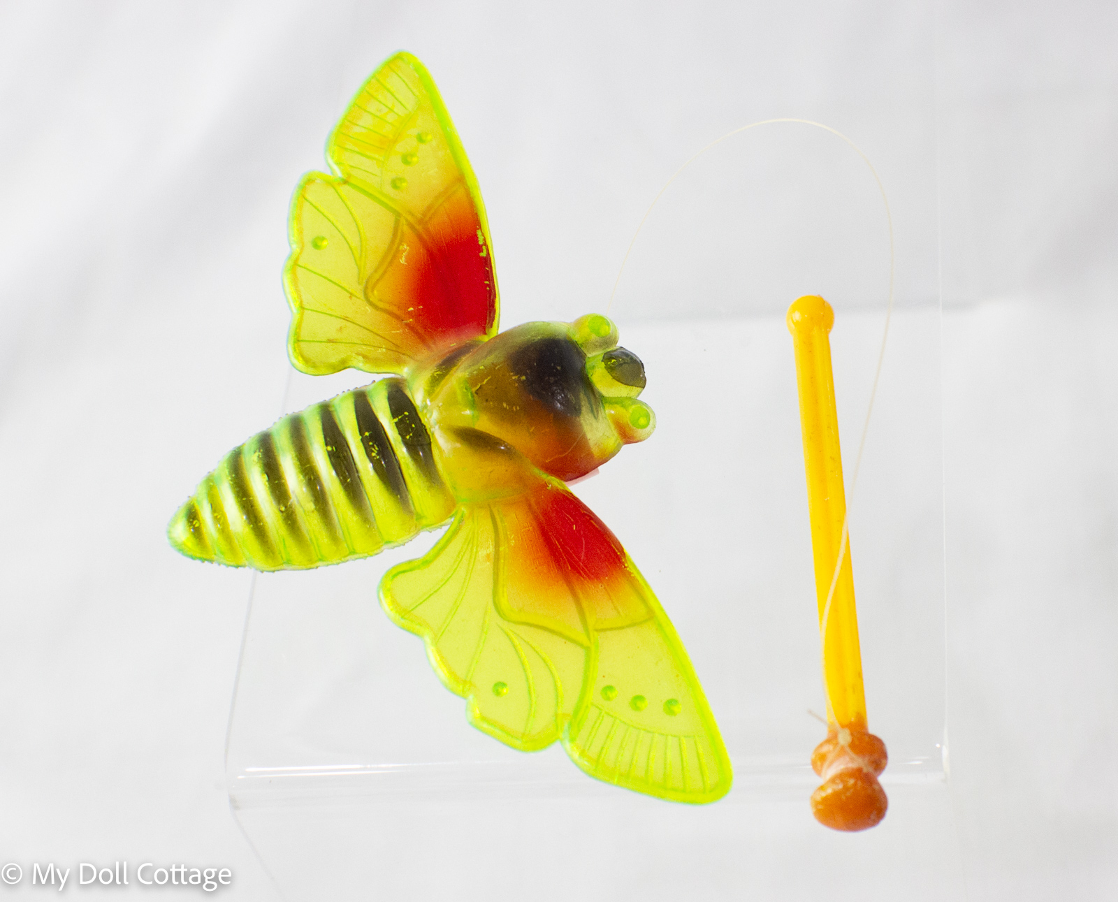 “Vintage Fairylite Busy Bee toy, 1950s translucent plastic with red and yellow wings on fishing line, made in Hong Kong, My Doll Cottage collection.