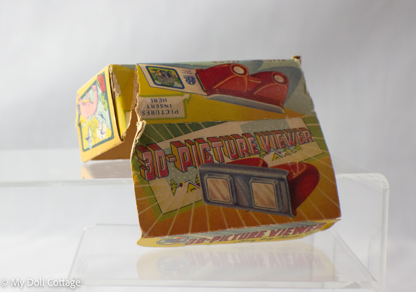 Close-up of damaged Empire Made 3D Picture Viewer box showing bright vintage graphics and torn edges.