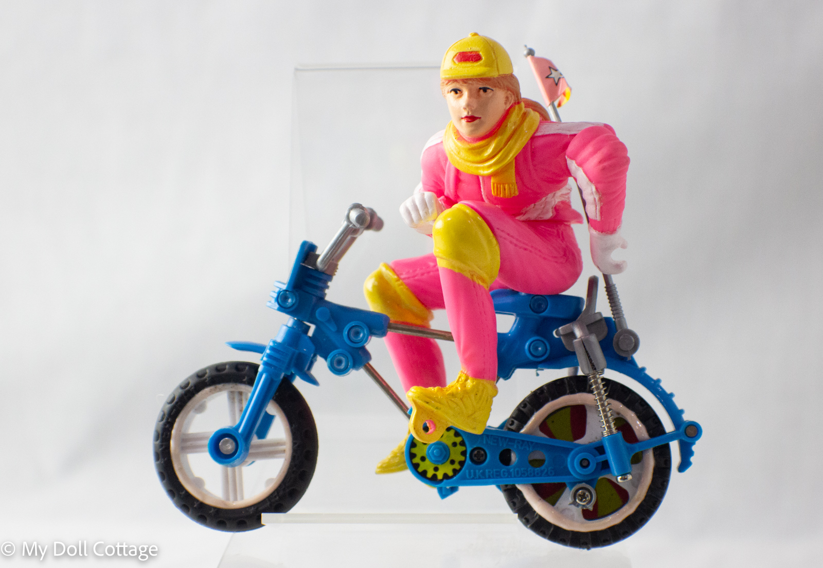 New-Ray Girl on Blue Friction Bike – 1980s