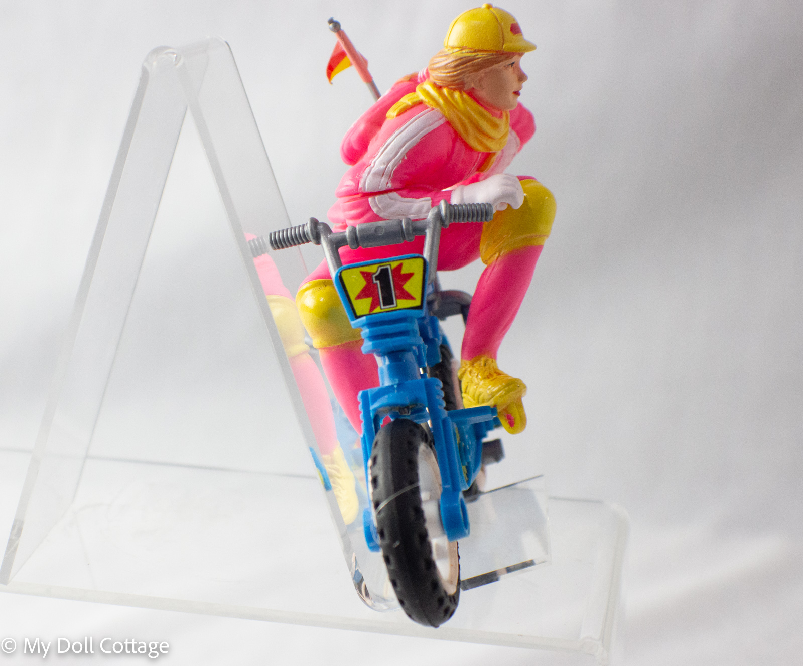 Rear view showing ponytail, flag, and detailed bike components.