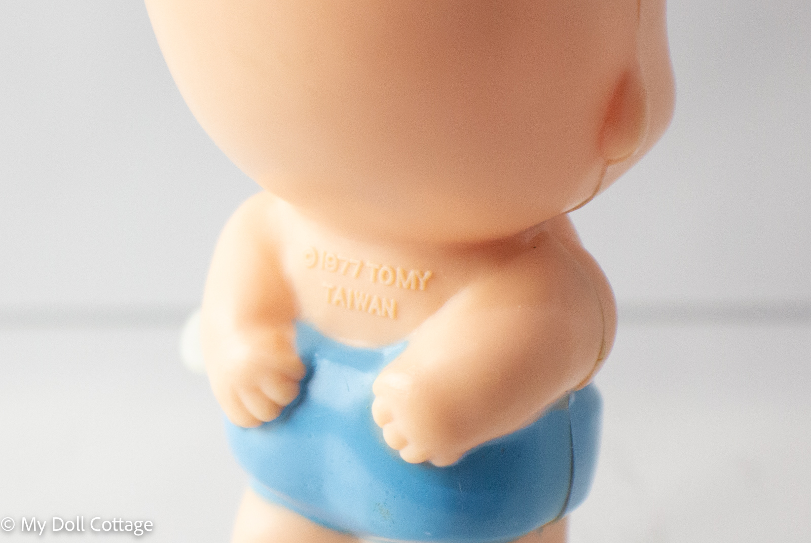 Close-up detail of Tomy copyright marking on baby’s back.