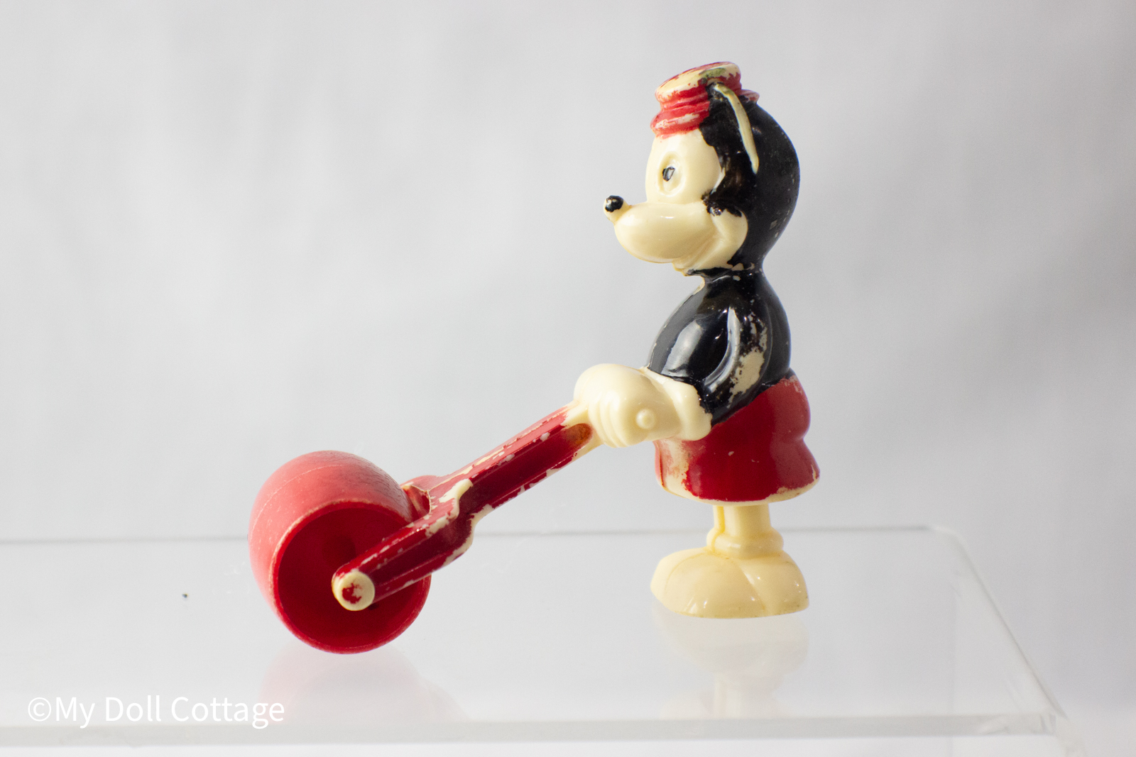 Side profile showing Mickey holding a red handle attached to the roller bar.