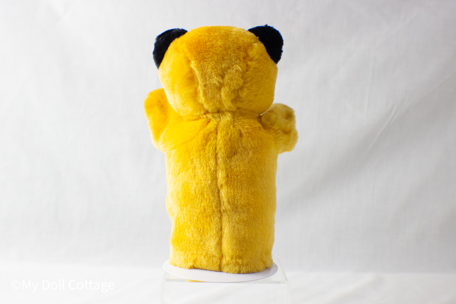 2.	Rear view of Sooty puppet showing full yellow plush body and black ear detailing.