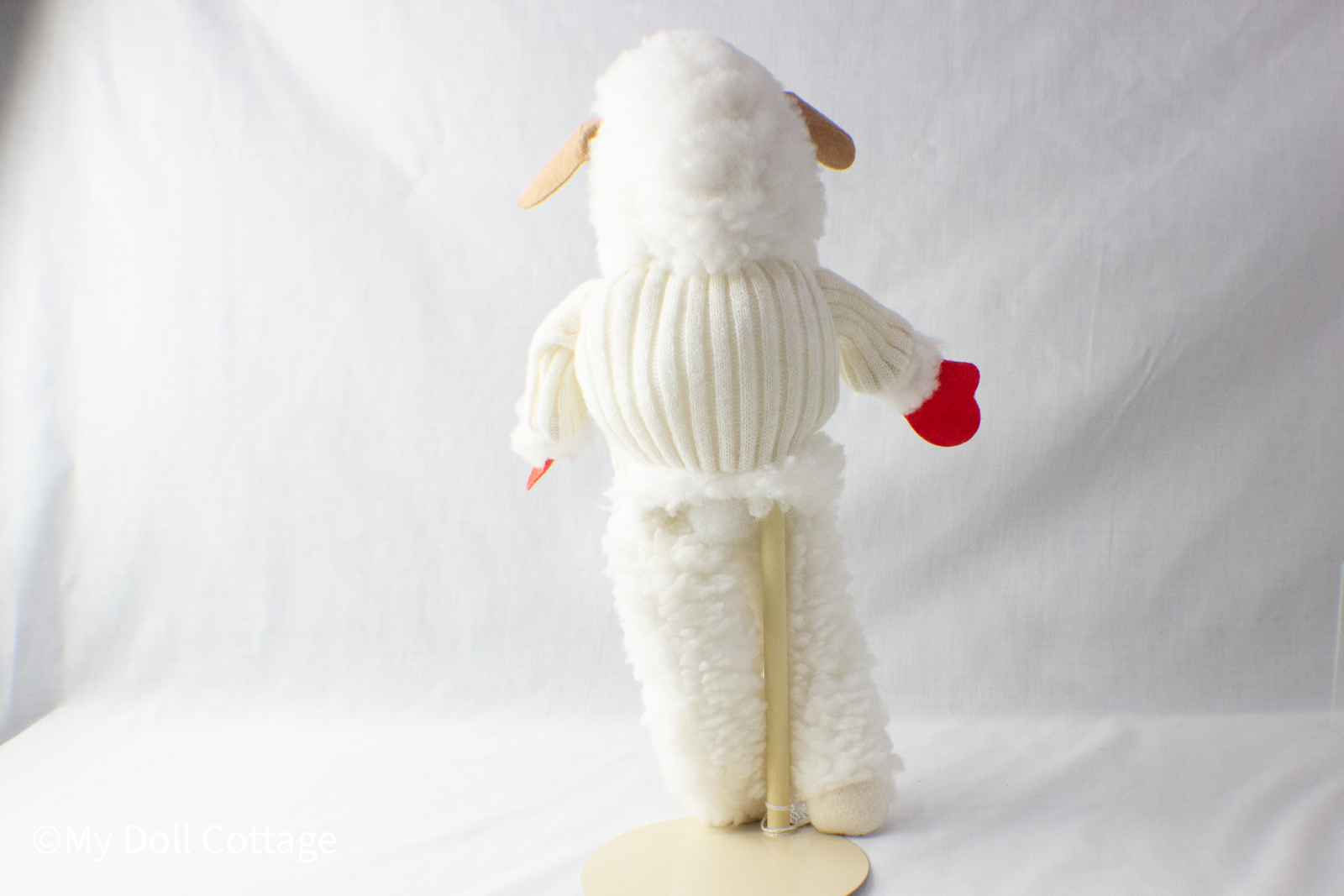 - Rear view showing plush texture and sweater detailing of 1960s Lamb Chop puppet.