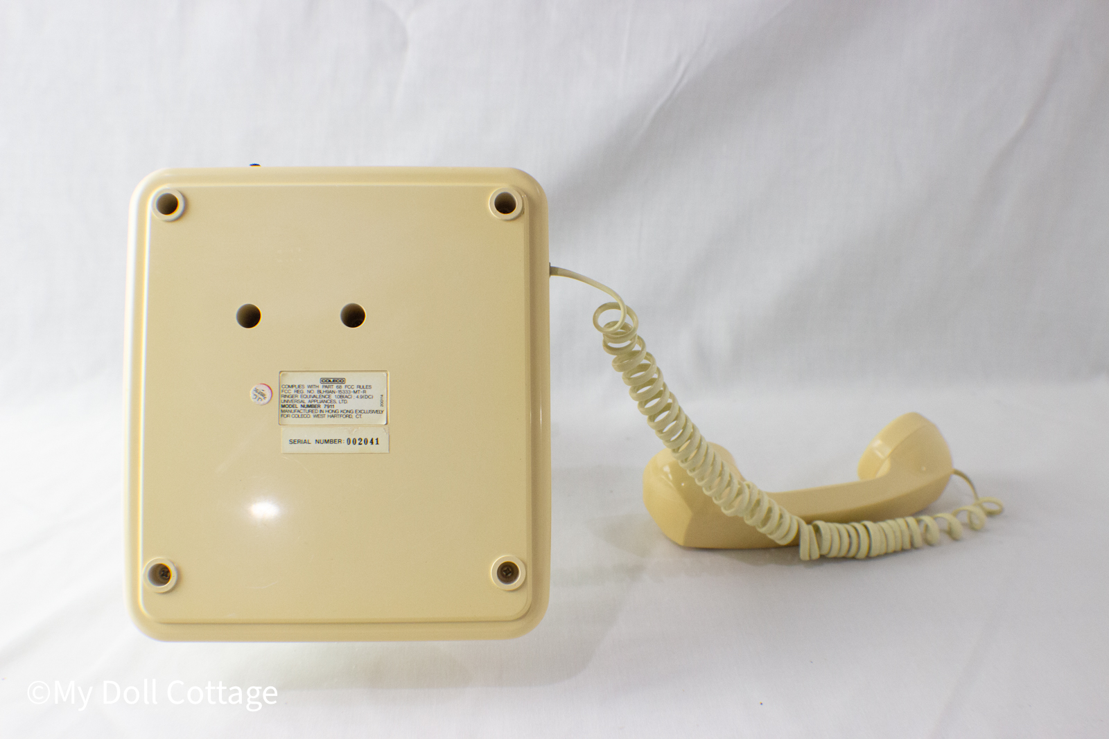 Underside of telephone with manufacturer label and serial number visible.