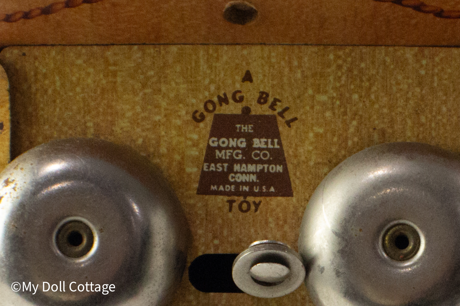 Extreme close-up of the Gong Bell Co. maker’s mark reading “A Gong Bell Toy – East Hampton Conn., Made in U.S.A.”