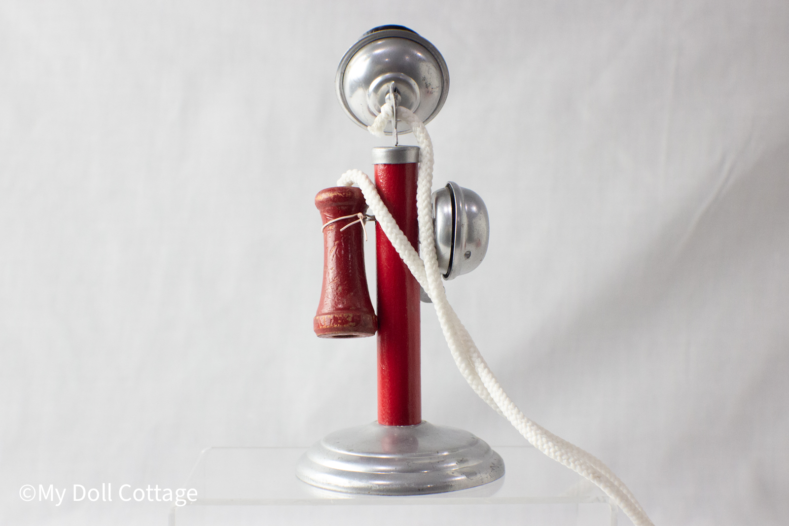 Rear view of toy telephone showing bell housing and rope attachment.