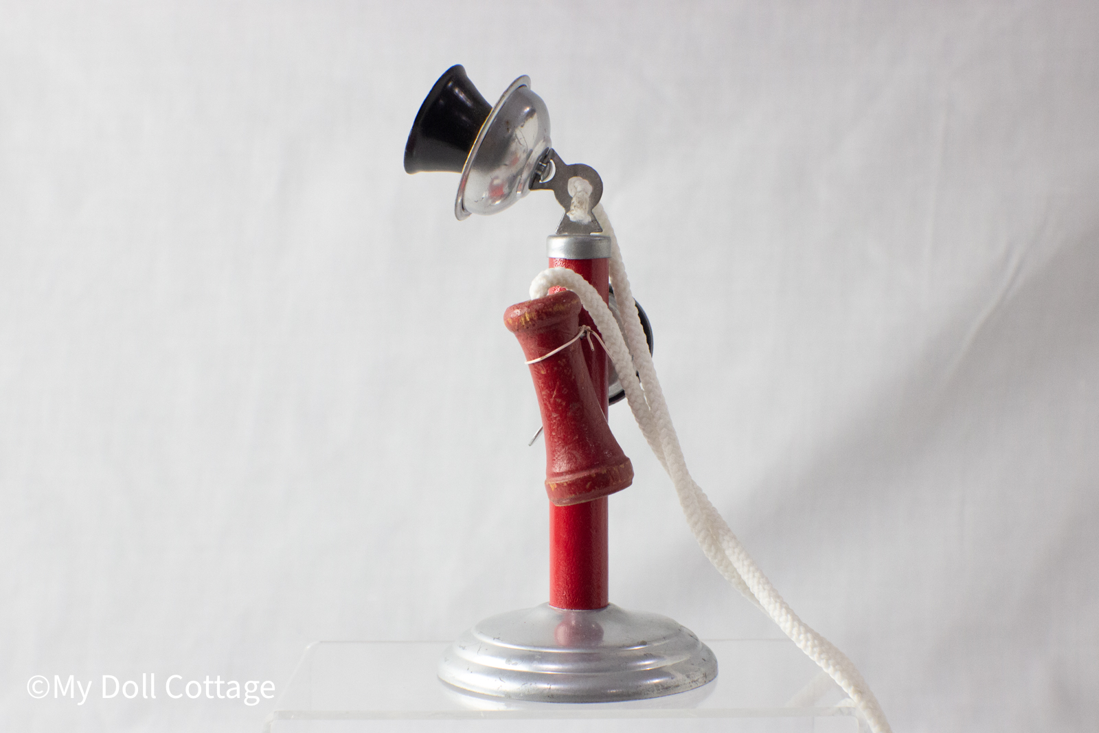 Right side view highlighting the red column, silver bell, and wooden receiver