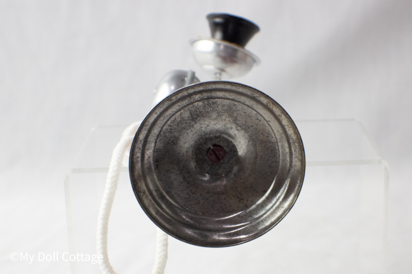 Close-up of silver round base with tarnish appropriate for age.